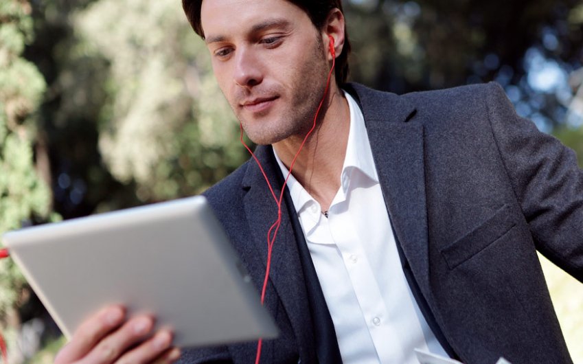 Hombre en el exterior suscribiéndose a través de una tablet a la Newsletter de Talleres Náser